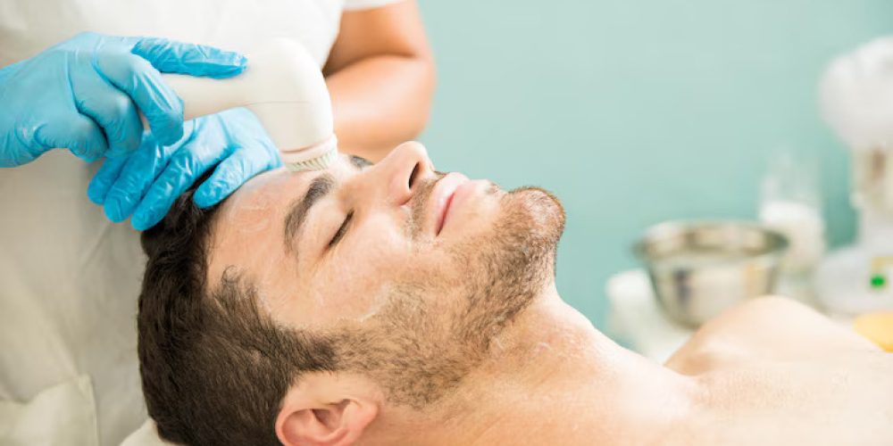 happy-young-man-getting-facial-exfoliation-scrub-with-brush-health-beauty-spa_662251-2543