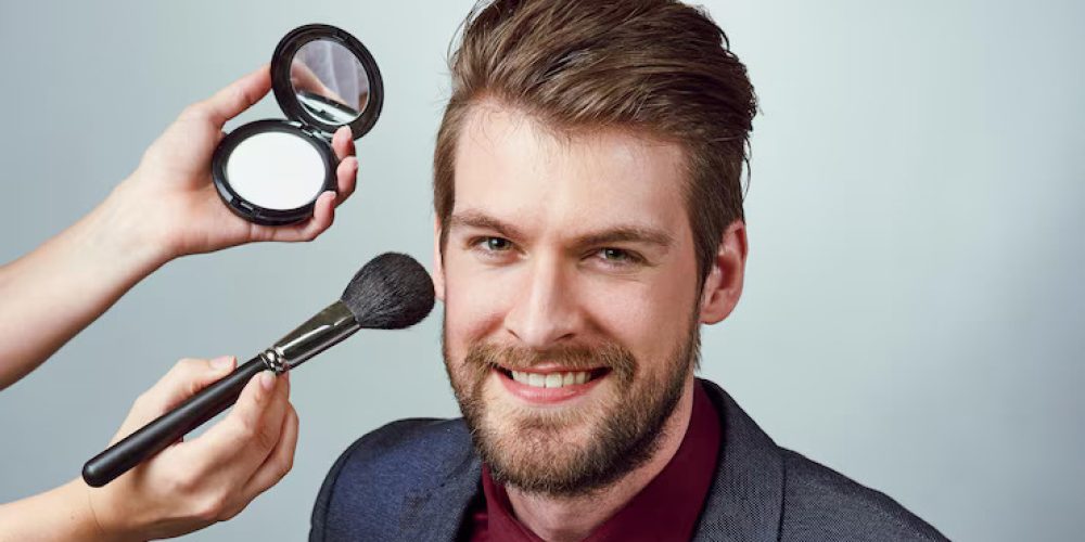 my-stylist-keeps-me-looking-sharp-studio-portrait-handsome-young-man-having-makeup-applied-his-face-against-gray-background_590464-18847
